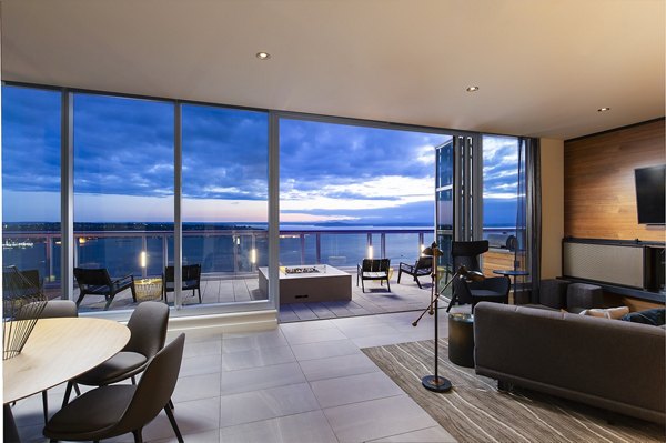 Modern living room with sleek furnishings at West Edge Apartments, featuring floor-to-ceiling windows and sophisticated decor