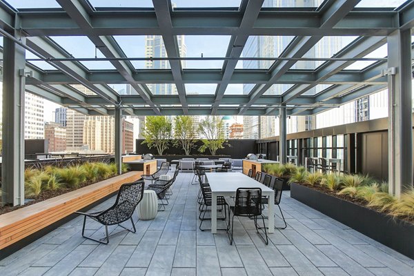 Spacious patio with modern furniture at West Edge Apartments, offering city skyline views perfect for relaxation and entertainment