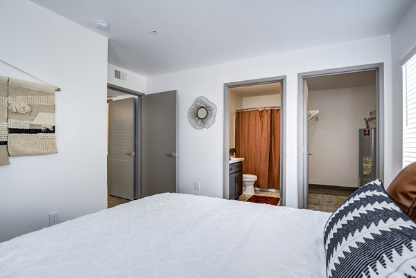 Cozy bedroom with modern decor at Lumen Apartments, highlighting comfort and style in urban living
