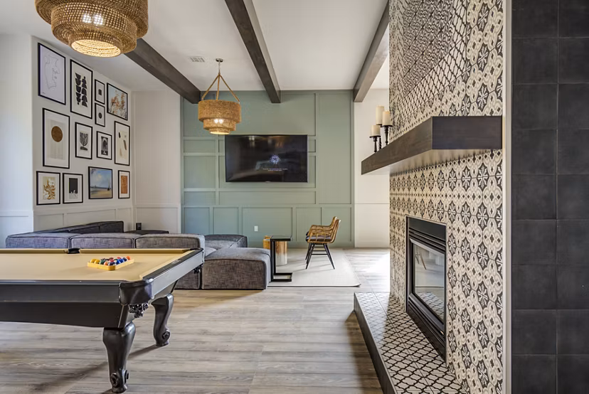 Lumen Apartments: Clubhouse game room with modern seating and billiards table, perfect for relaxing and socializing in a luxury environment