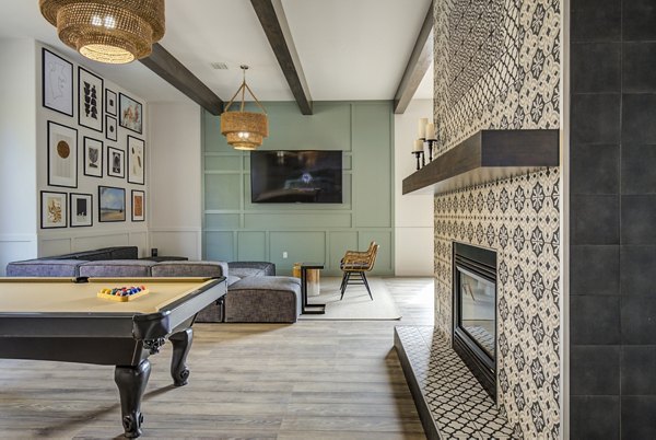 Lumen Apartments: Clubhouse game room with modern seating and billiards table, perfect for relaxing and socializing in a luxury environment