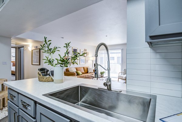Modern kitchen featuring sleek appliances and granite countertops at Lumen Apartments luxury high-rise