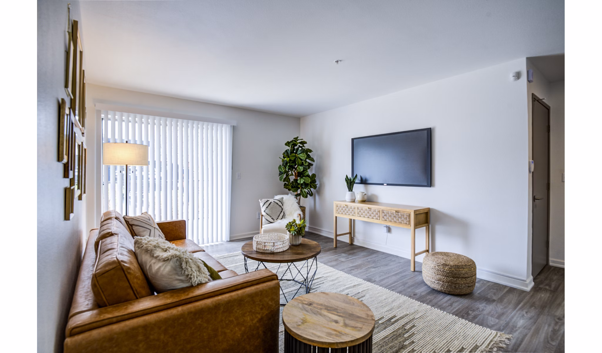 Open concept living room with modern furniture and large windows at Lumen Apartments