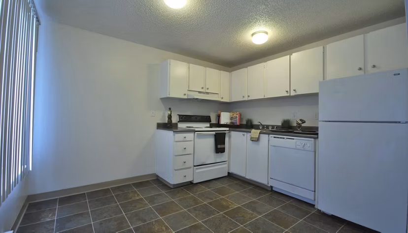 Kitchen featuring modern appliances and sleek countertops at The Woodmark Apartments