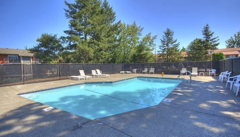 Modern outdoor pool with lounge chairs at The Woodmark Apartments