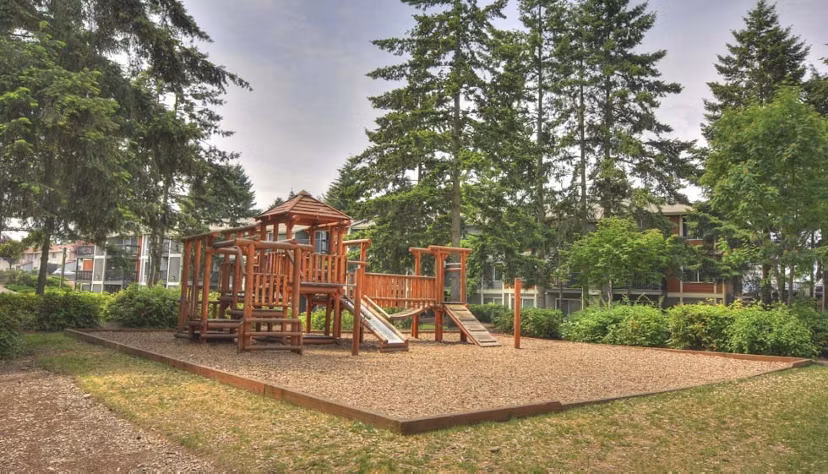 Children's playground at The Woodmark Apartments featuring modern play equipment and landscaped surroundings
