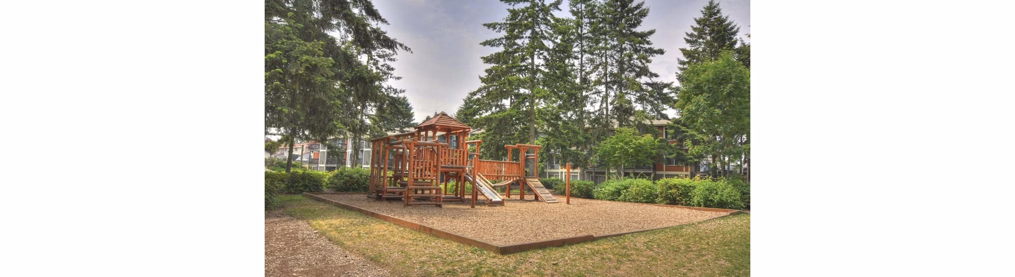 Children's playground at The Woodmark Apartments featuring modern play equipment and landscaped surroundings