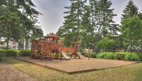 Children's playground at The Woodmark Apartments featuring modern play equipment and landscaped surroundings