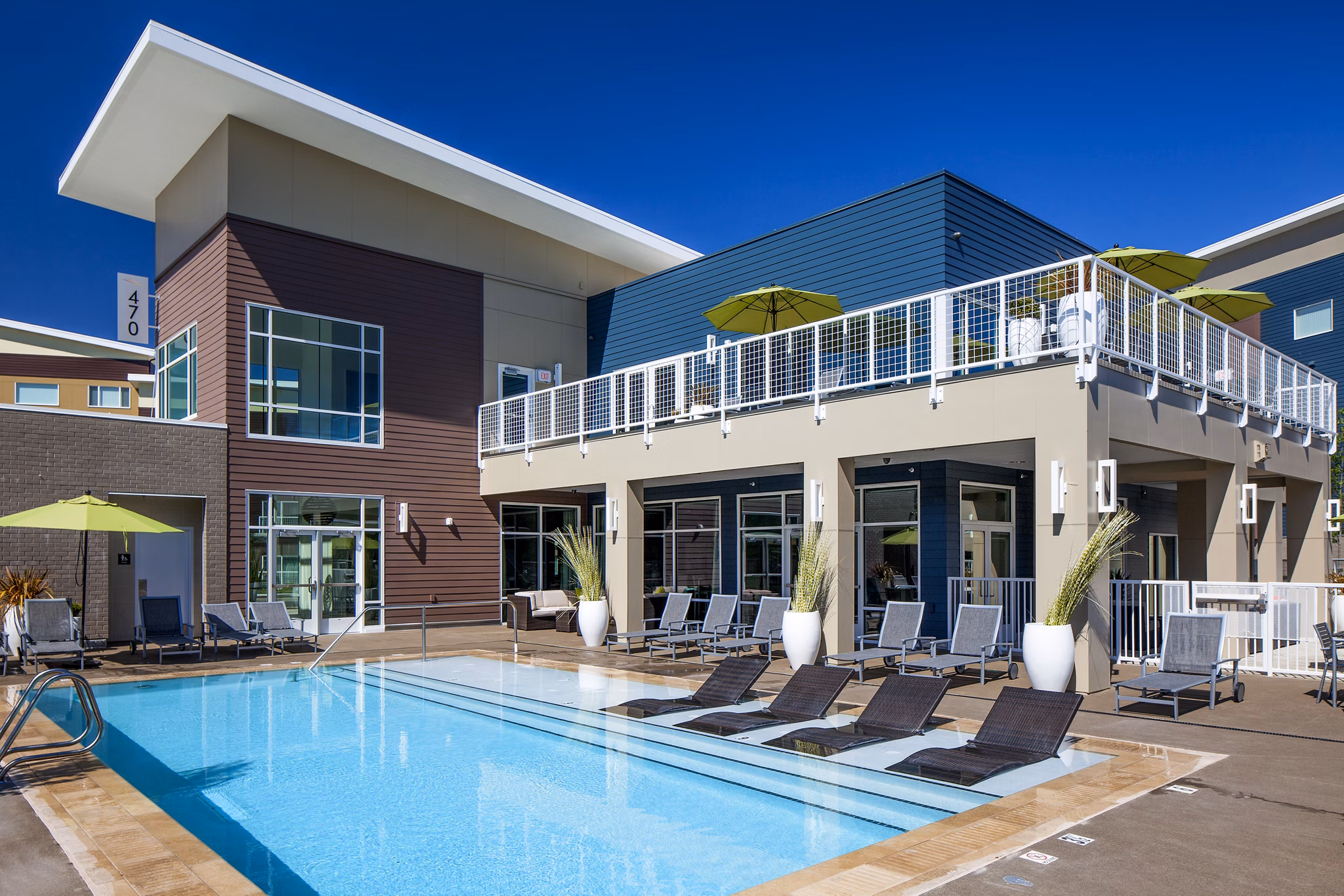 Riverside pool with lounge chairs at Riverwalk Apartments