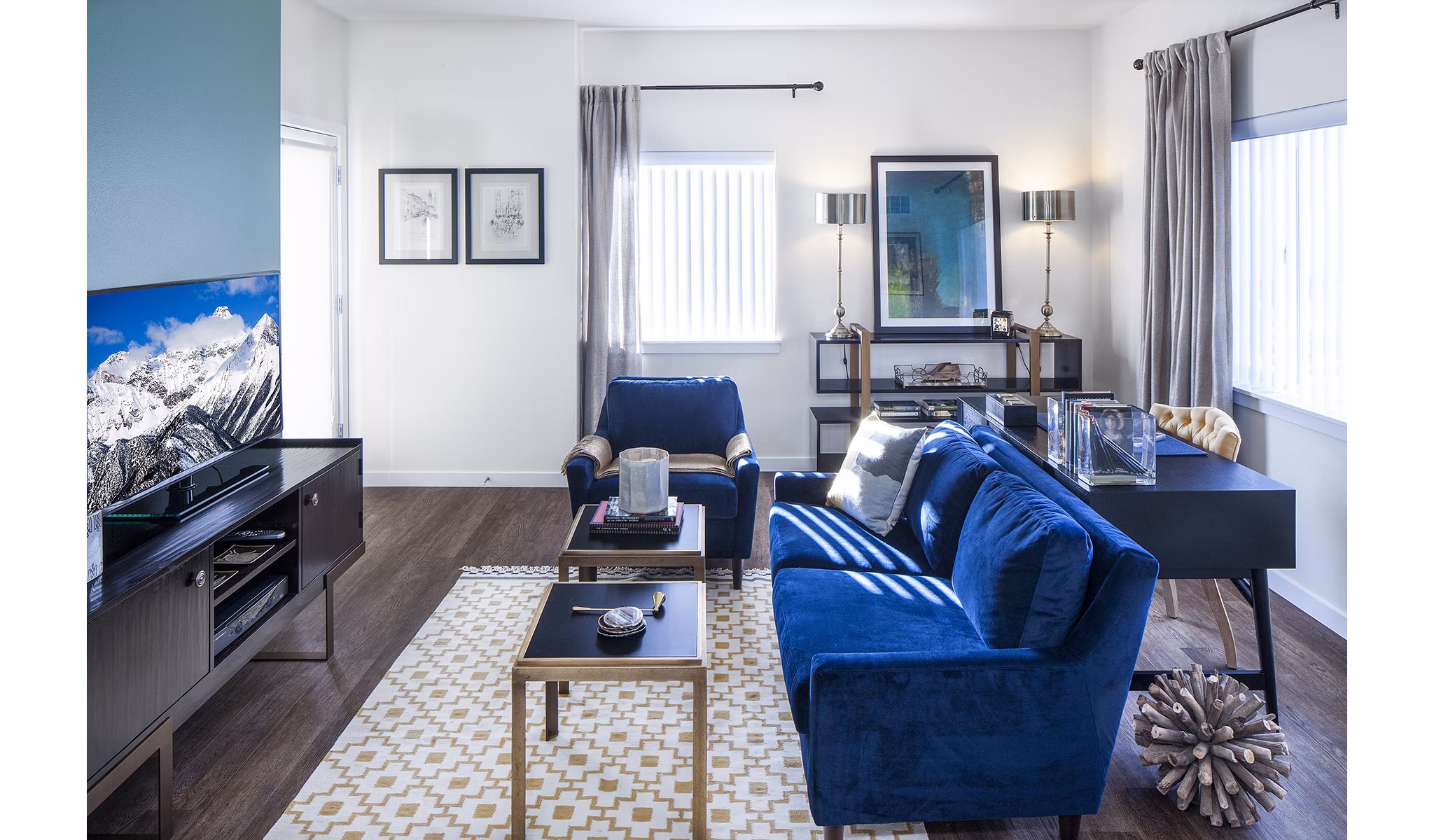 Spacious living room with modern decor in Riverwalk Apartments, offering luxury living with abundant natural light and stylish furnishings
