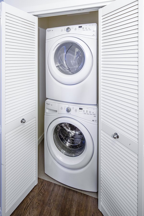 Laundry room with modern appliances at Riverwalk Apartments, offering convenient amenities for luxury living