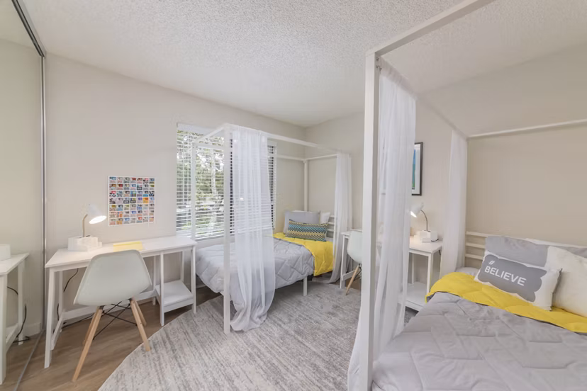 The Hilltop Apartments: Cozy bedroom with modern decor and ample natural light, perfect for luxurious living