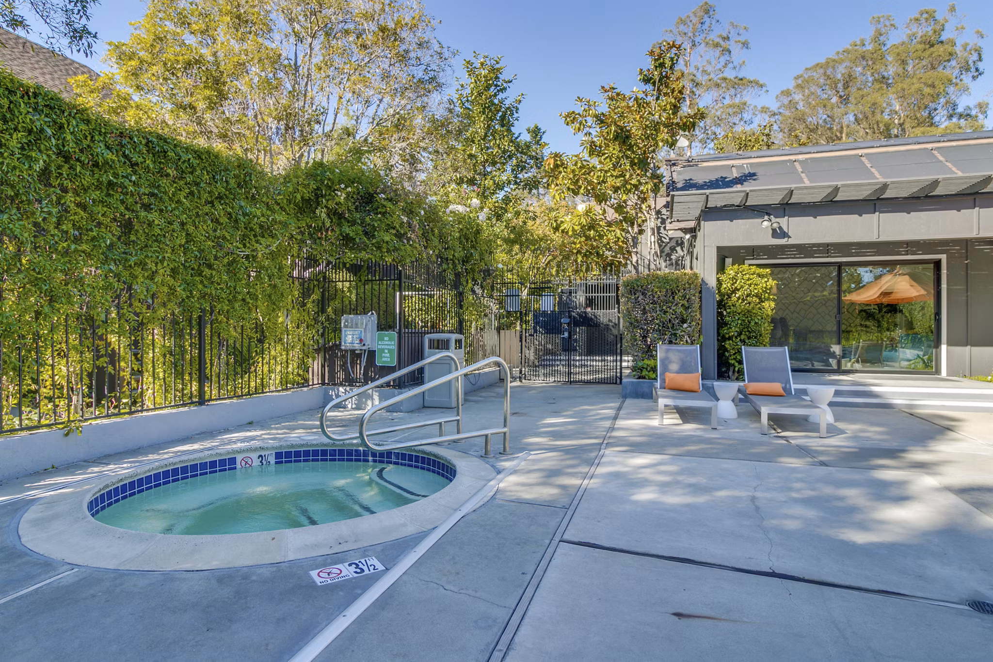 Outdoor swimming pool with lounge chairs at The Hilltop Apartments, offering luxury living and relaxation in a serene setting