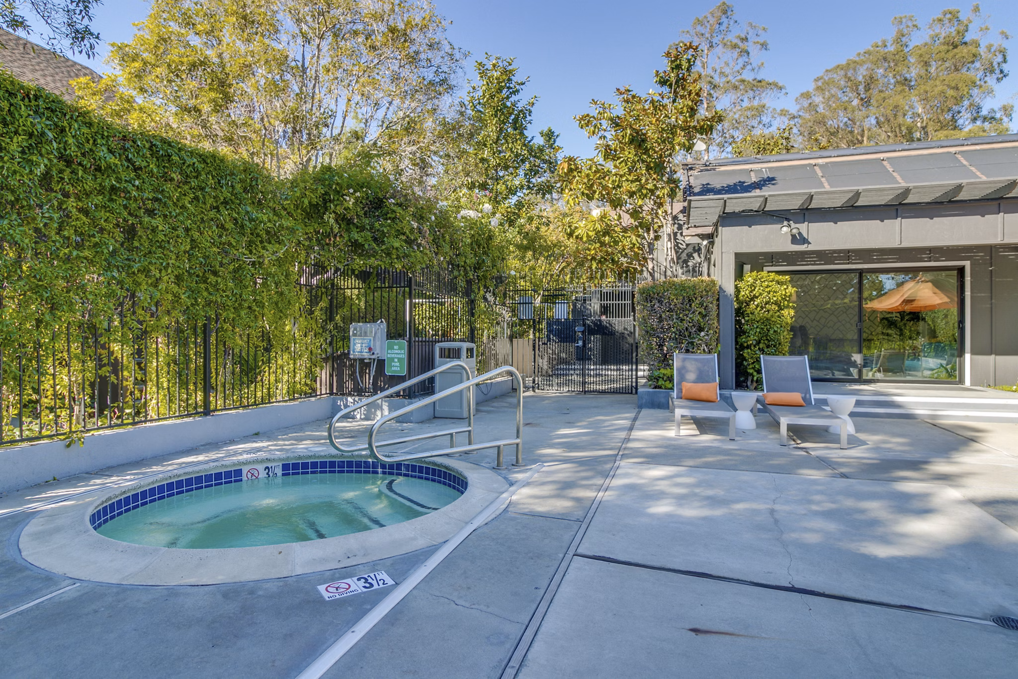 Outdoor swimming pool with lounge chairs at The Hilltop Apartments, offering luxury living and relaxation in a serene setting