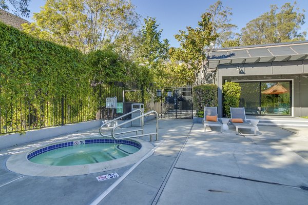 Outdoor swimming pool with lounge chairs at The Hilltop Apartments, offering luxury living and relaxation in a serene setting