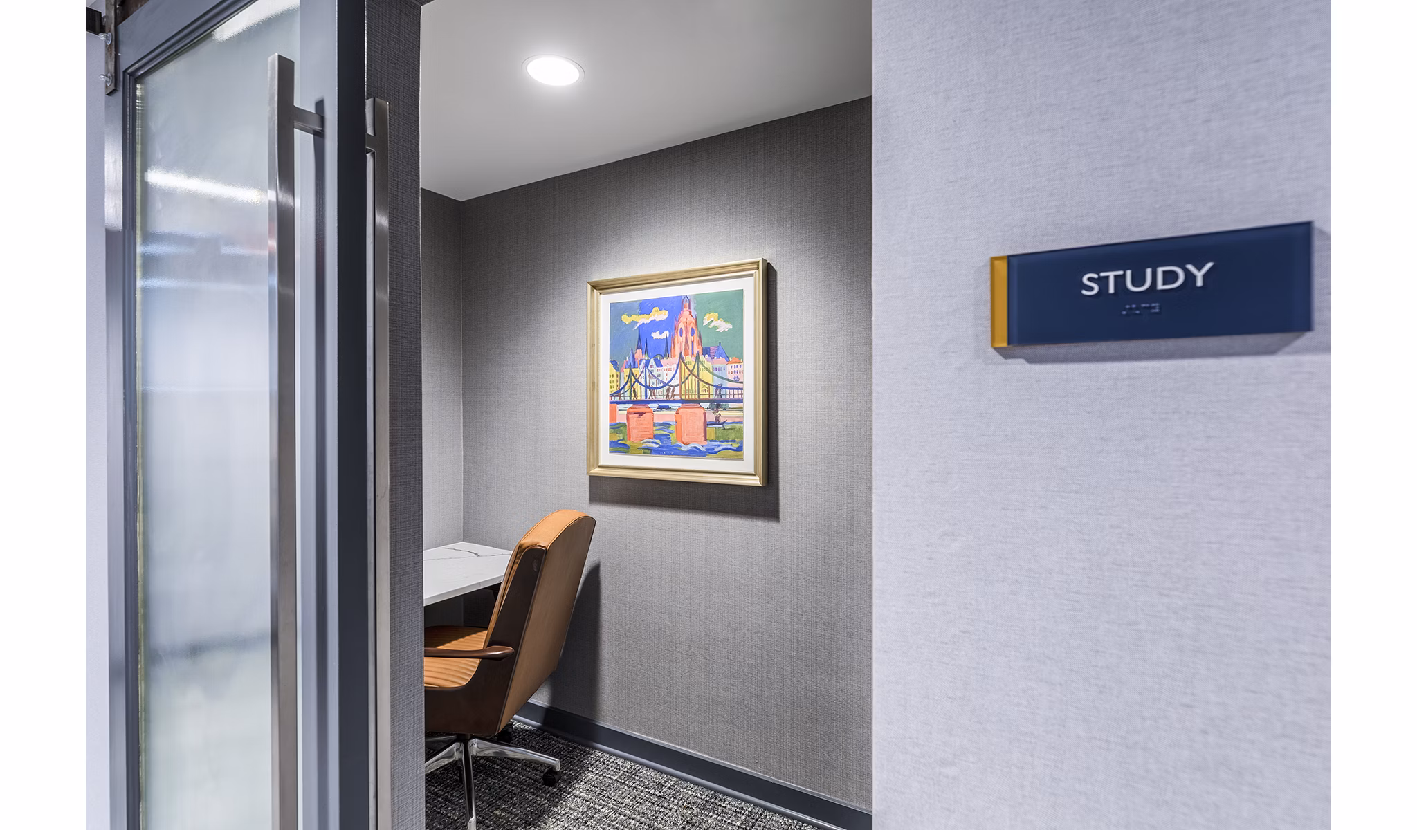 Study area featuring modern desks and cozy seating in Delwyn Apartments