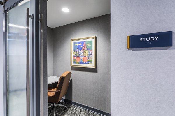 Study area featuring modern desks and cozy seating in Delwyn Apartments