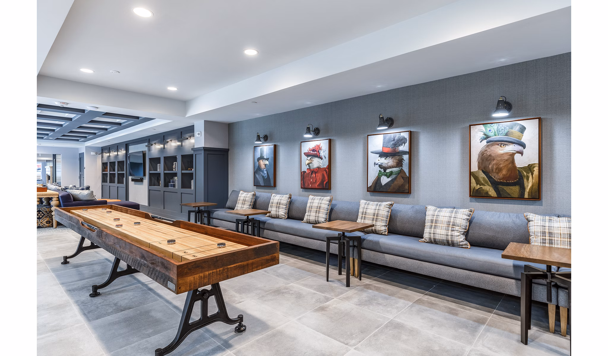 Modern lounge area with shuffleboard table and cozy seating in luxury apartments