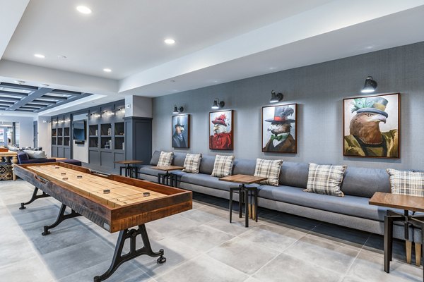 Modern lounge area with shuffleboard table and cozy seating in luxury apartments