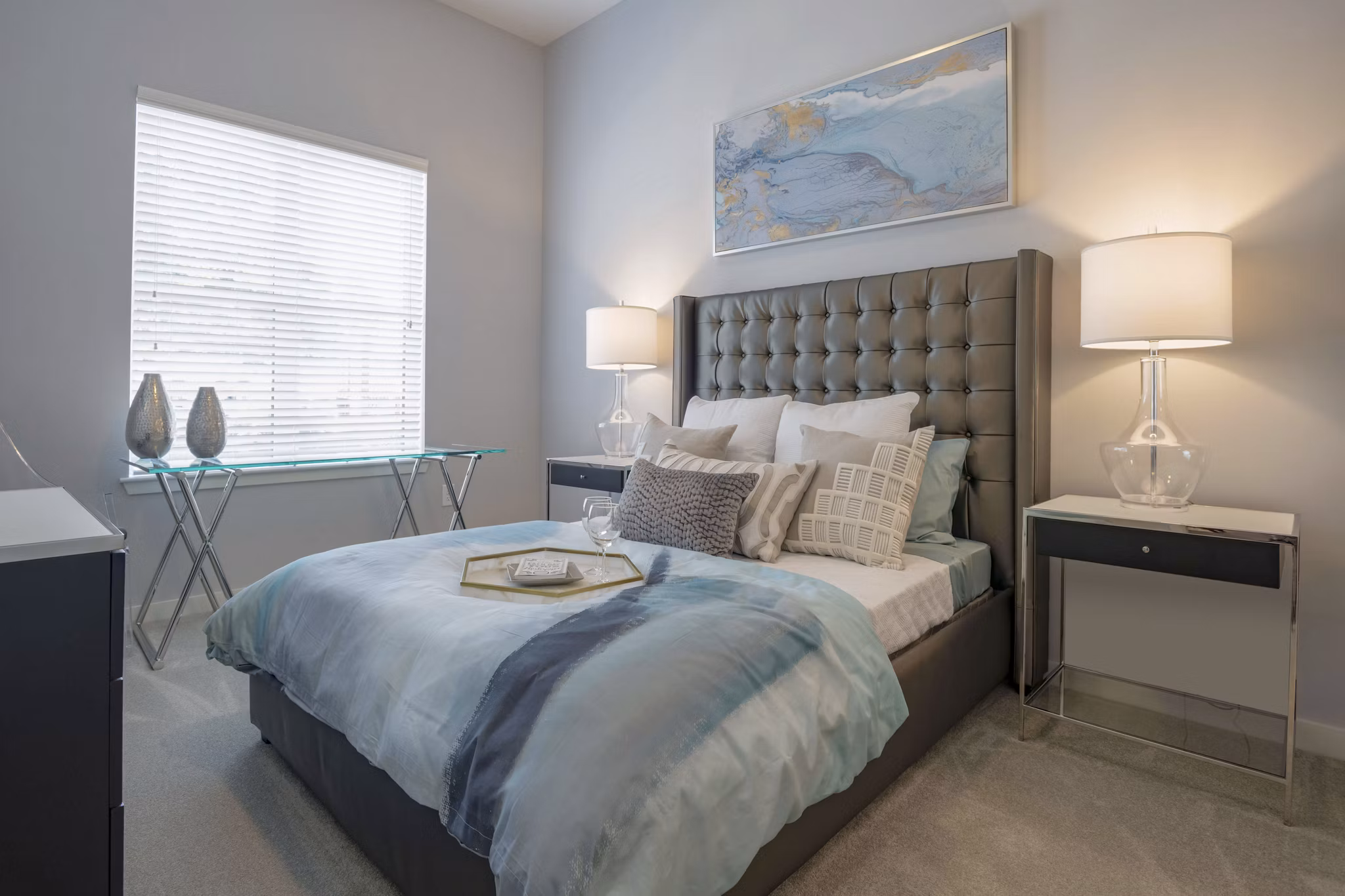 Cozy bedroom with modern decor at Aston City Springs Apartments, featuring plush bedding and ample natural light