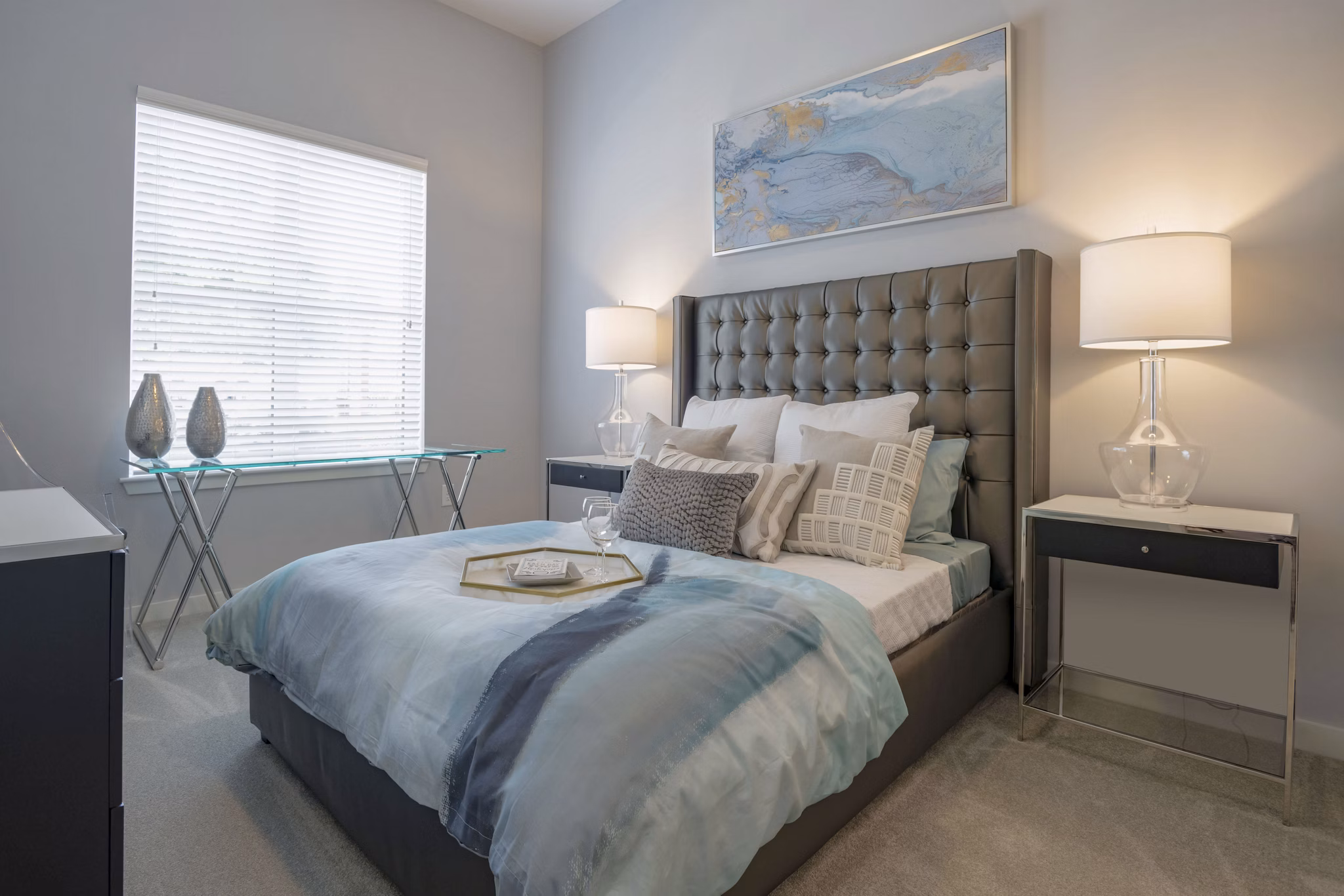 Cozy bedroom with modern decor at Aston City Springs Apartments, featuring plush bedding and ample natural light