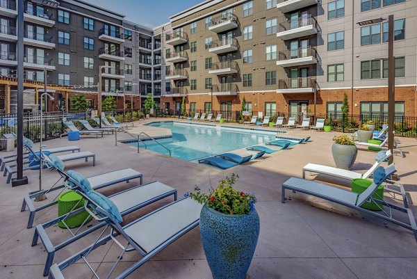 Spacious pool with sun loungers at Aston City Springs Apartments - luxury living in a vibrant community