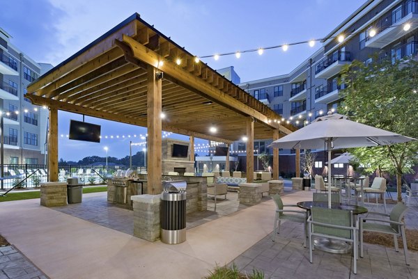 Outdoor grilling area with modern seating at Aston City Springs Apartments, offering a perfect spot for socializing and entertaining
