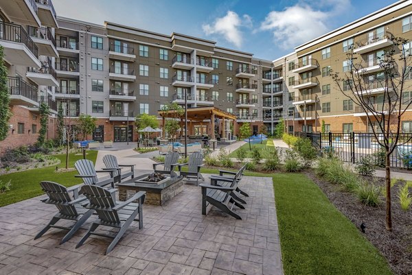 Cozy fire pit seating area at Aston City Springs Apartments, offering a relaxing outdoor space for residents