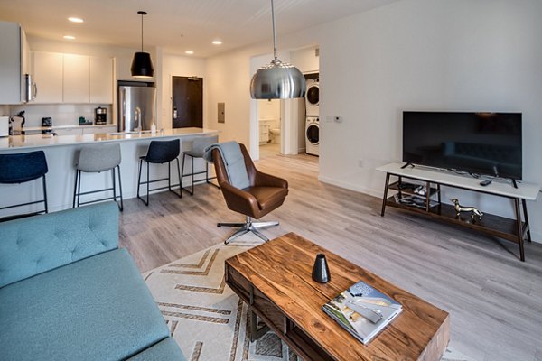 Spacious living room featuring modern decor and large windows at Second and Second Apartments in the Greystar luxury collection