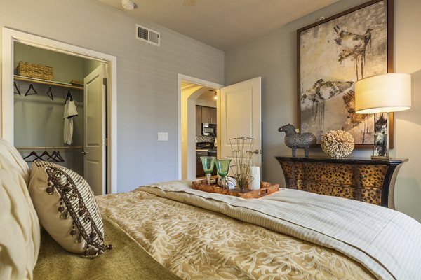 Modern bedroom featuring elegant decor and large windows at SkyStone Apartments, a luxury living experience near downtown