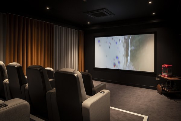 Cinema room at Greenford Quay Tillermans with luxurious seating and a large screen for an immersive viewing experience.