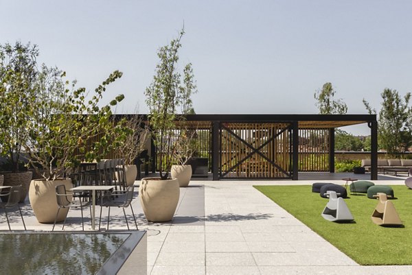Outdoor patio at Greenford Quay Tillermans with seating, greenery, and a beautifully landscaped garden area.