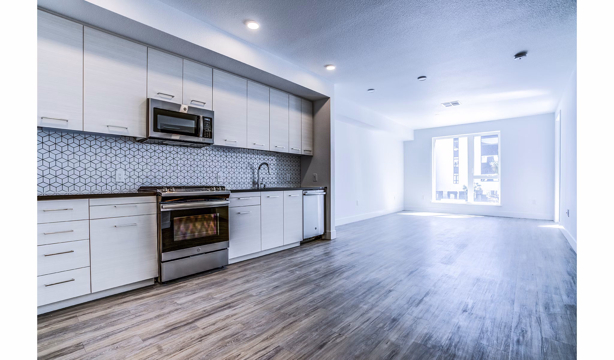 Savoy Apartments: Modern kitchen with stainless steel appliances and granite countertops in Greystar luxury community