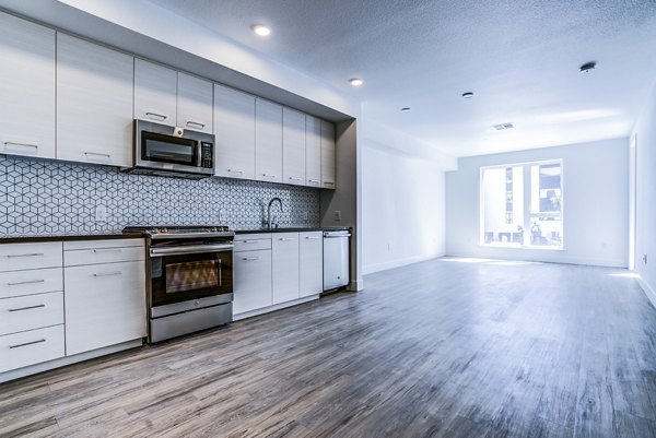 Savoy Apartments: Modern kitchen with stainless steel appliances and granite countertops in Greystar luxury community