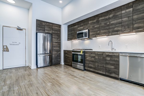 Spacious kitchen with granite countertops and stainless steel appliances in Savoy Apartments