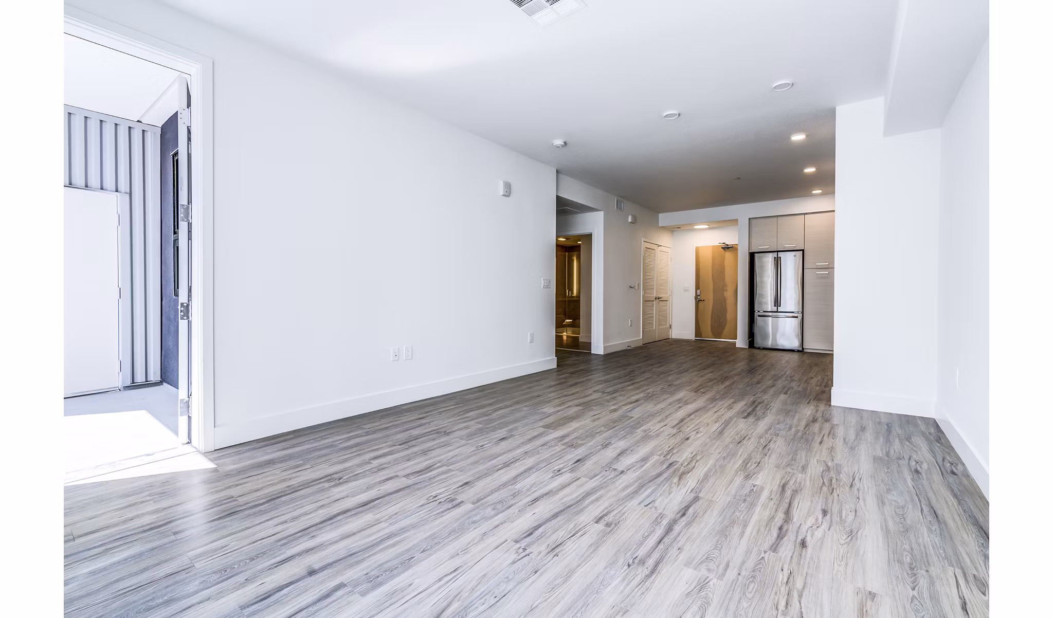 Spacious living room with modern decor and ample natural light at Savoy Apartments