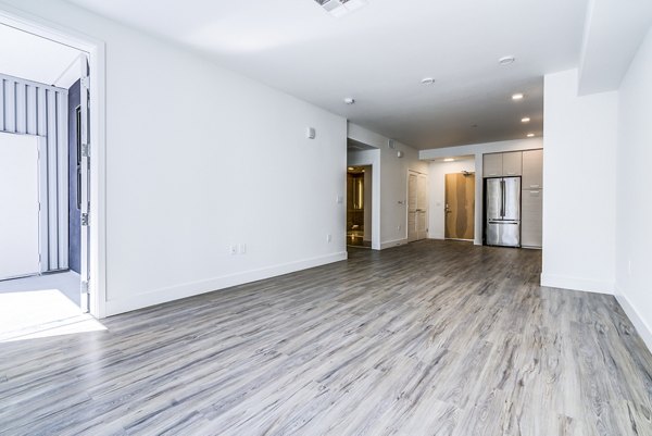 Spacious living room with modern decor and ample natural light at Savoy Apartments