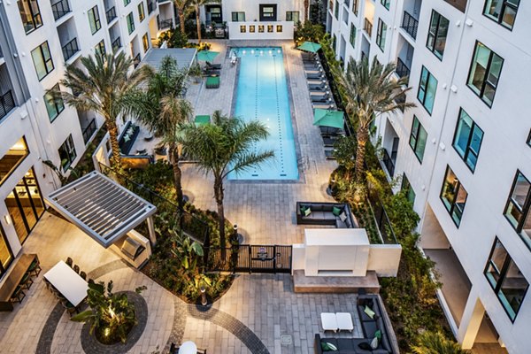 Sunny outdoor pool at Savoy Apartments with comfortable lounge chairs
