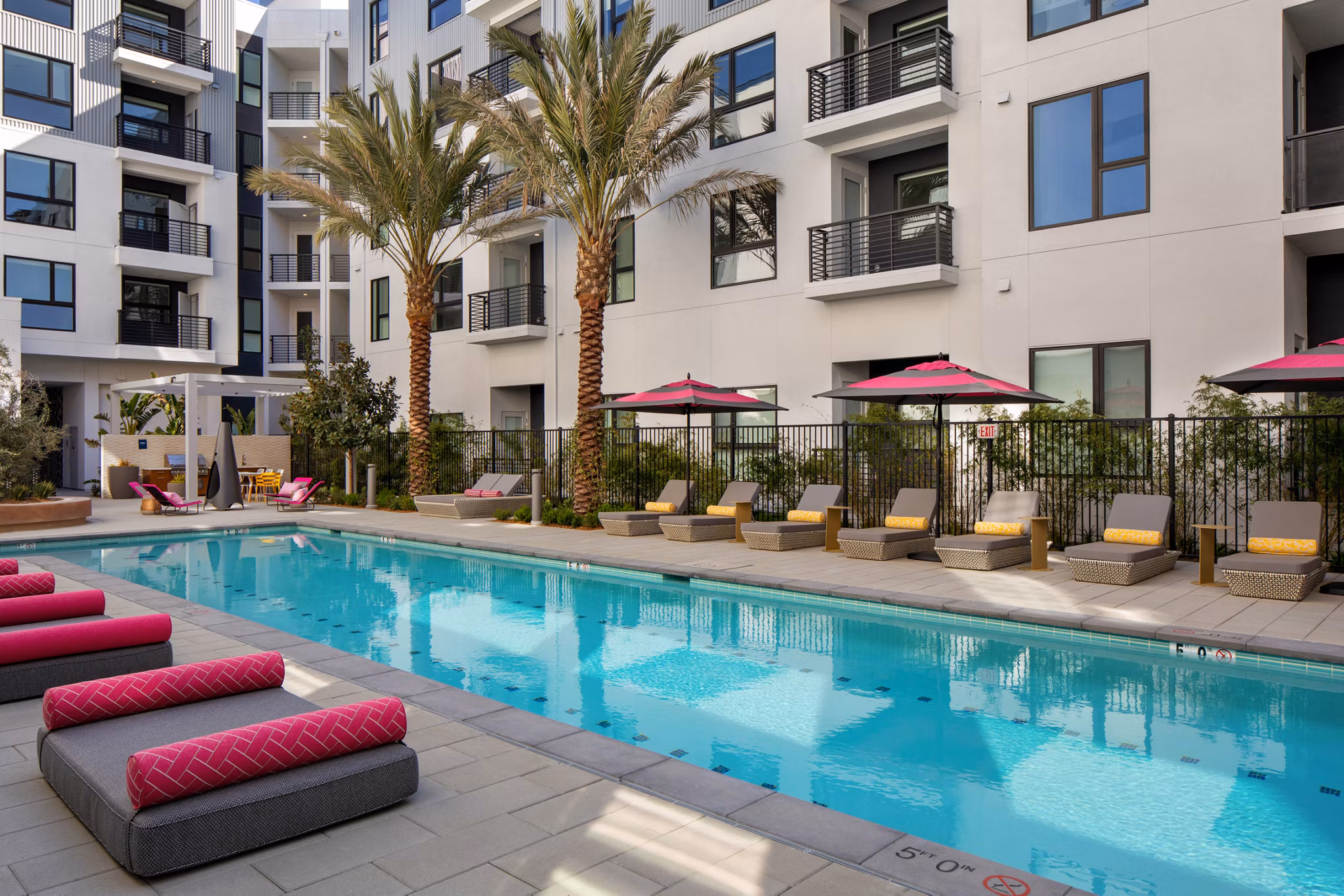Sparkling outdoor pool at Savoy Apartments with surrounding lounge chairs in a luxurious setting