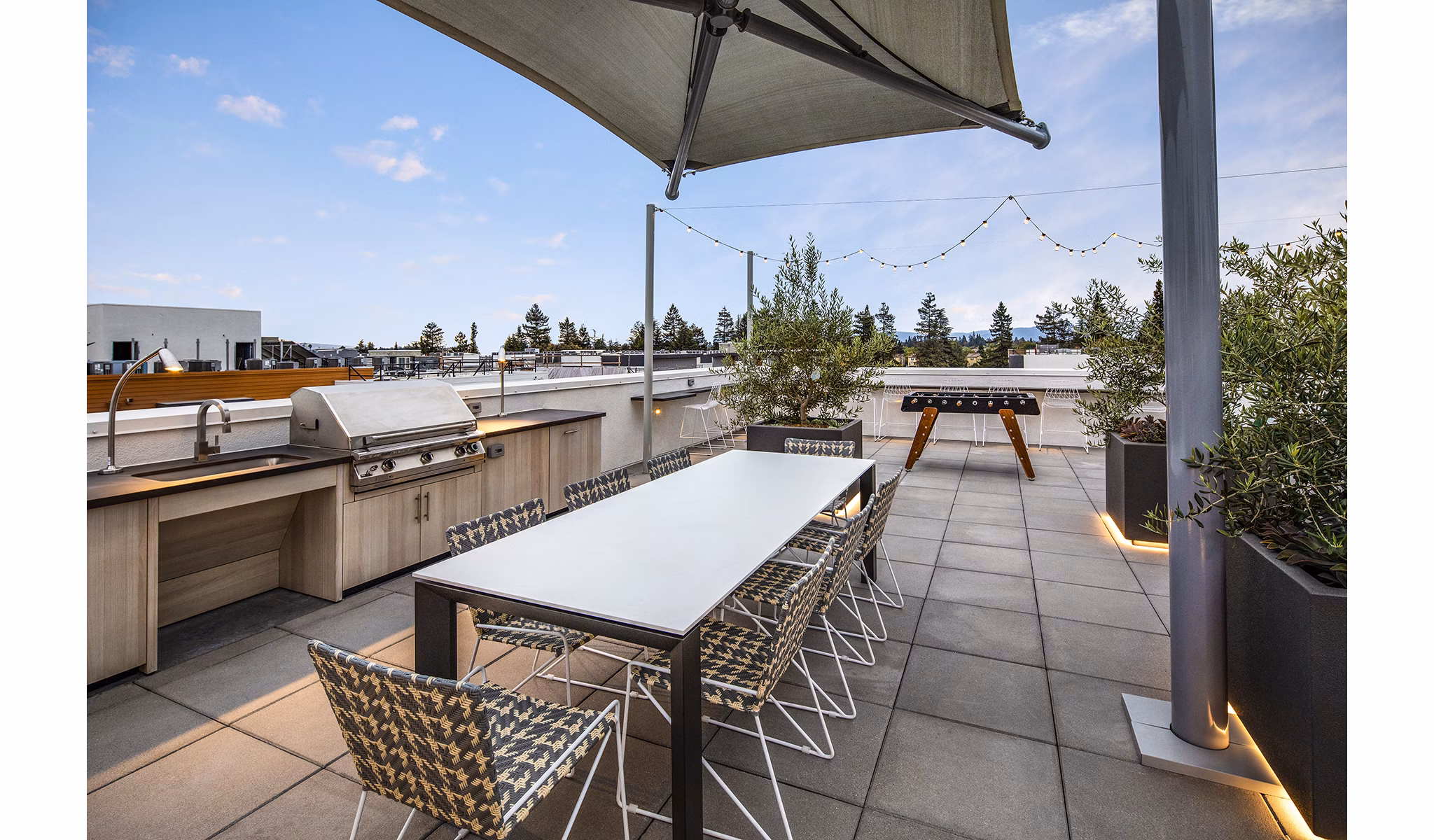 Outdoor grill area with modern seating at Savoy Apartments, offering a perfect space for social gatherings and dining under the sky