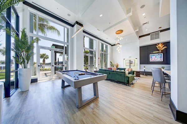 Clubhouse game room with billiards and lounge seating at Navette on the Bay Apartments, featuring luxury amenities for residents