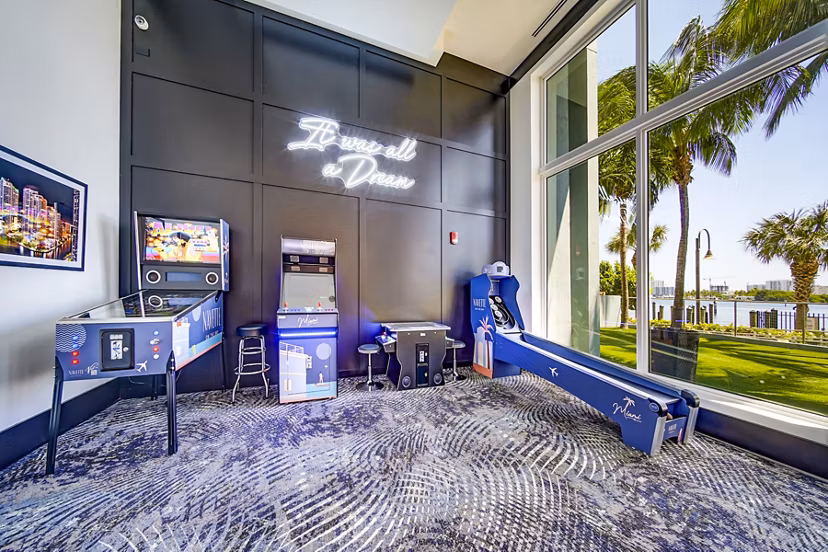 Clubhouse game room featuring billiards and cozy seating at Navette on the Bay Apartments
