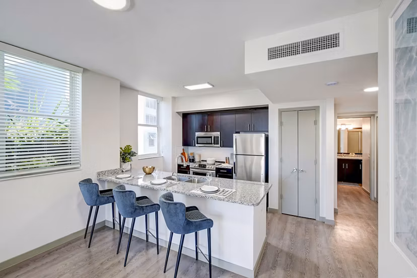 Modern kitchen with stainless steel appliances and quartz countertops at Navette on the Bay Apartments