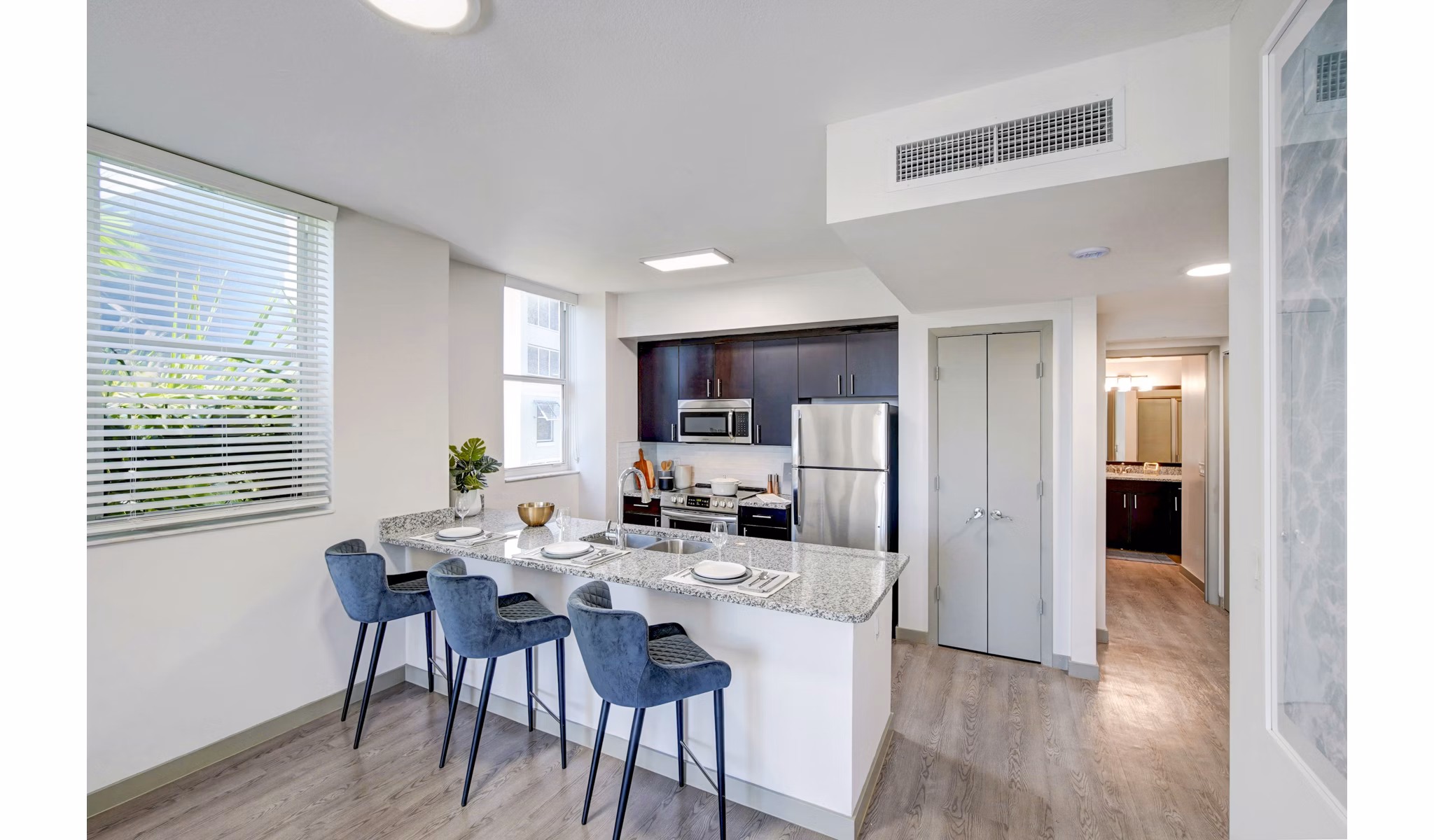 Modern kitchen with stainless steel appliances and quartz countertops at Navette on the Bay Apartments