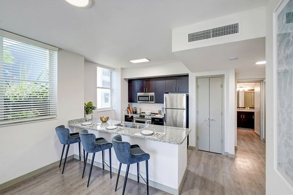 Modern kitchen with stainless steel appliances and quartz countertops at Navette on the Bay Apartments
