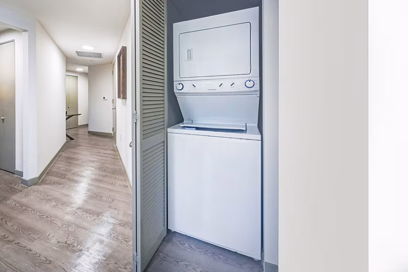 Laundry room with modern appliances at Navette on the Bay Apartments