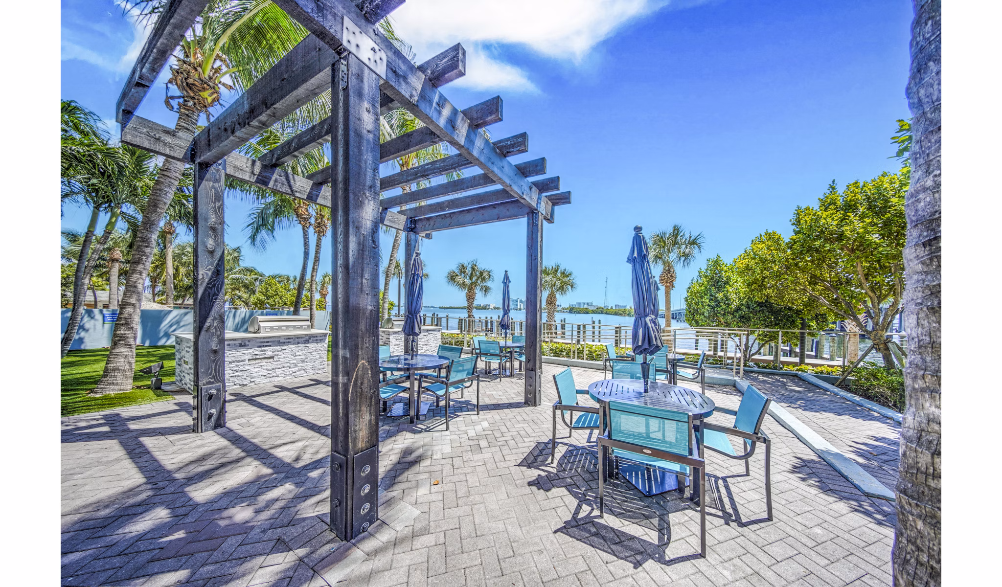Grill area patio with barbecue stations at Navette on the Bay Apartments with outdoor seating