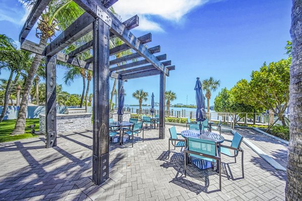 Grill area patio with barbecue stations at Navette on the Bay Apartments with outdoor seating