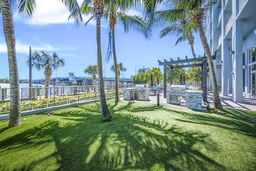 Outdoor grill area with modern patio furniture at Navette on the Bay Apartments