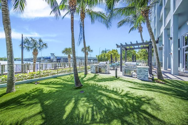Outdoor grill area with modern patio furniture at Navette on the Bay Apartments